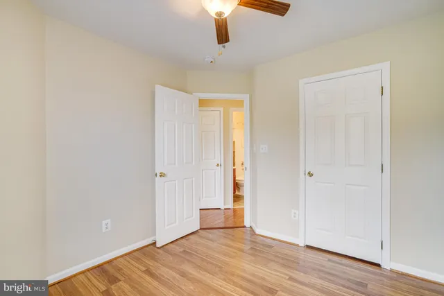 an empty room with wooden floor cabinet and windows