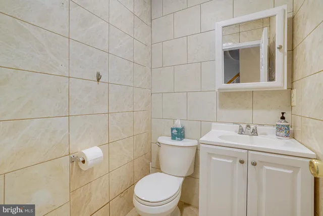 a bathroom with a toilet sink vanity and mirror