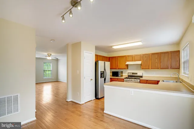 a kitchen with a refrigerator a stove and cabinets