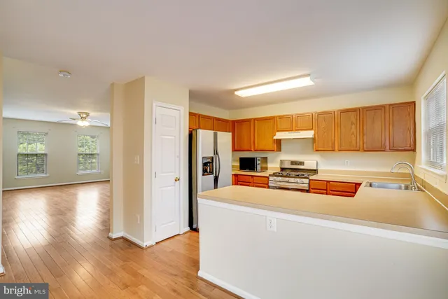 a view of a kitchen with kitchen island a sink a stove and a refrigerator