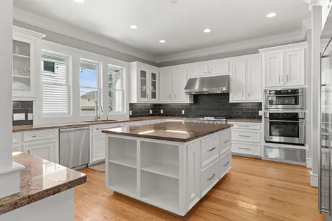 a large kitchen with stainless steel appliances granite countertop a stove a sink and a microwave
