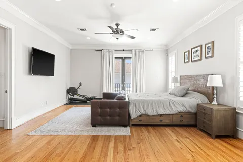 a spacious bedroom with a bed a couch and a flat screen tv