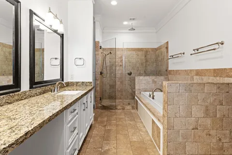 a spacious bathroom with a granite countertop sink mirror and shower