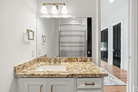 a bathroom with a granite countertop sink and a mirror