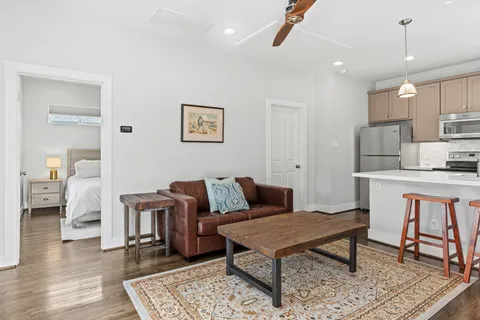 a living room with furniture a rug and kitchen view