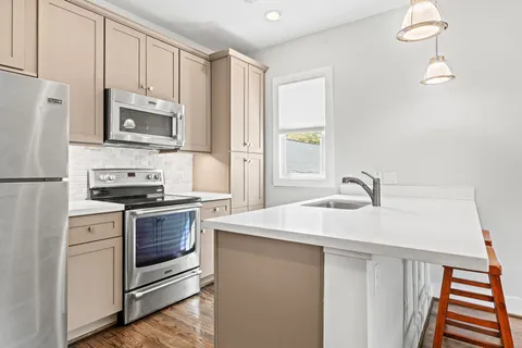 a kitchen with stainless steel appliances a stove microwave and refrigerator