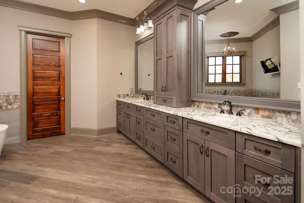 a spacious bathroom with a double vanity sink a large mirror and shower