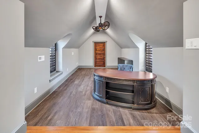 a kitchen with granite countertop a refrigerator a sink and wooden floor