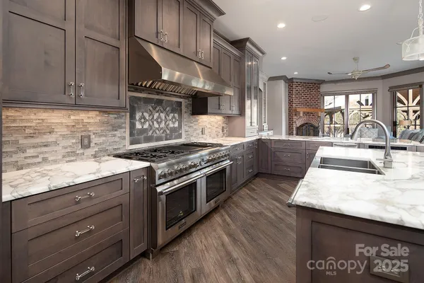 a kitchen with stainless steel appliances granite countertop a sink stove and cabinets