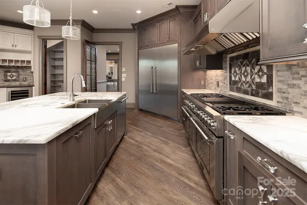 a kitchen with stainless steel appliances granite countertop a sink and a stove