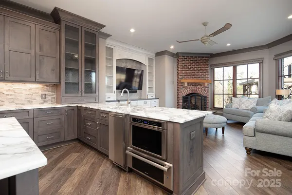 a kitchen with a stove a sink and a refrigerator with wooden floor