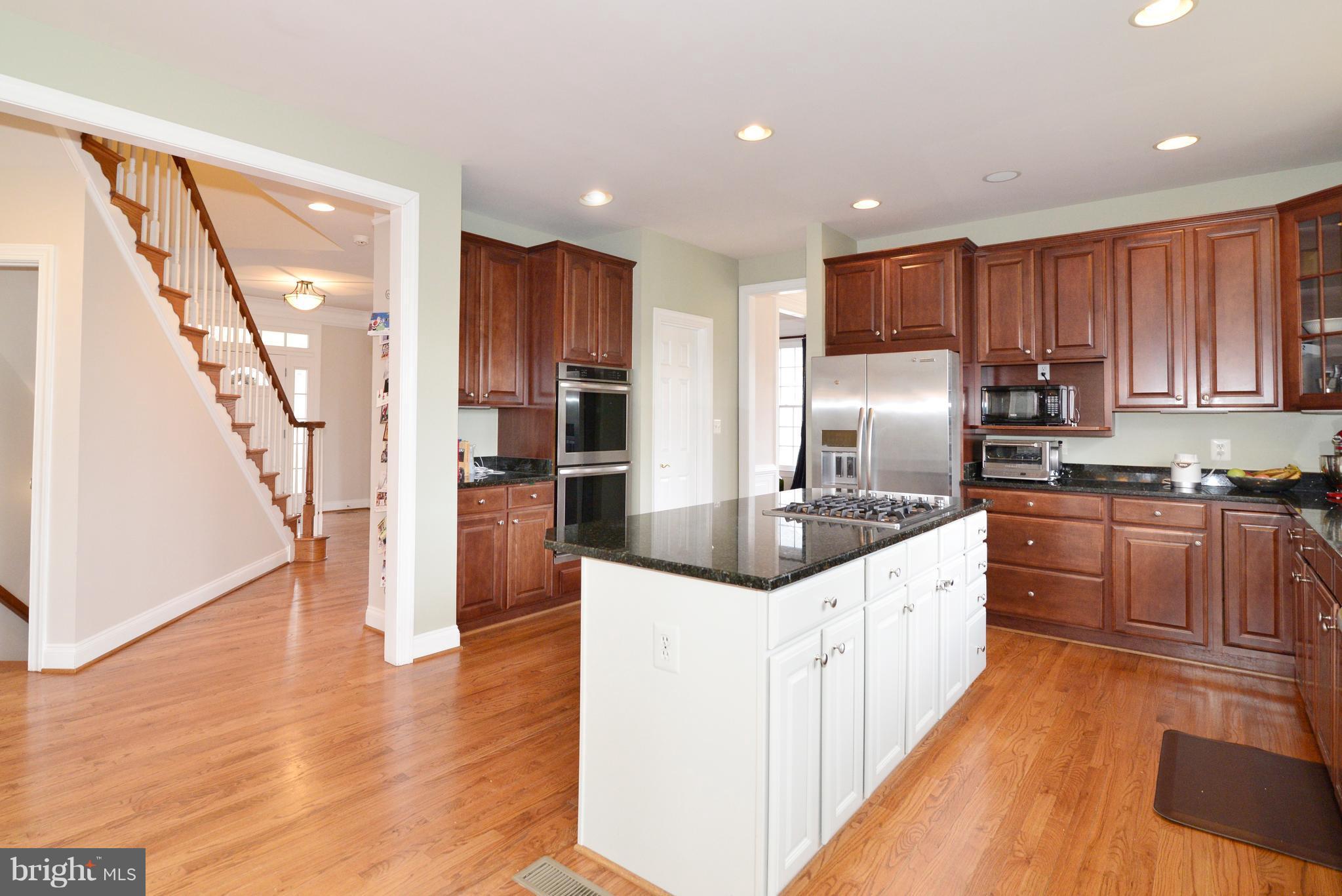 1763 Proffit Road Vienna, VA 22182 - Photo 14 of 30 a kitchen with stainless steel appliances granite countertop a refrigerator a stove and a wooden floors