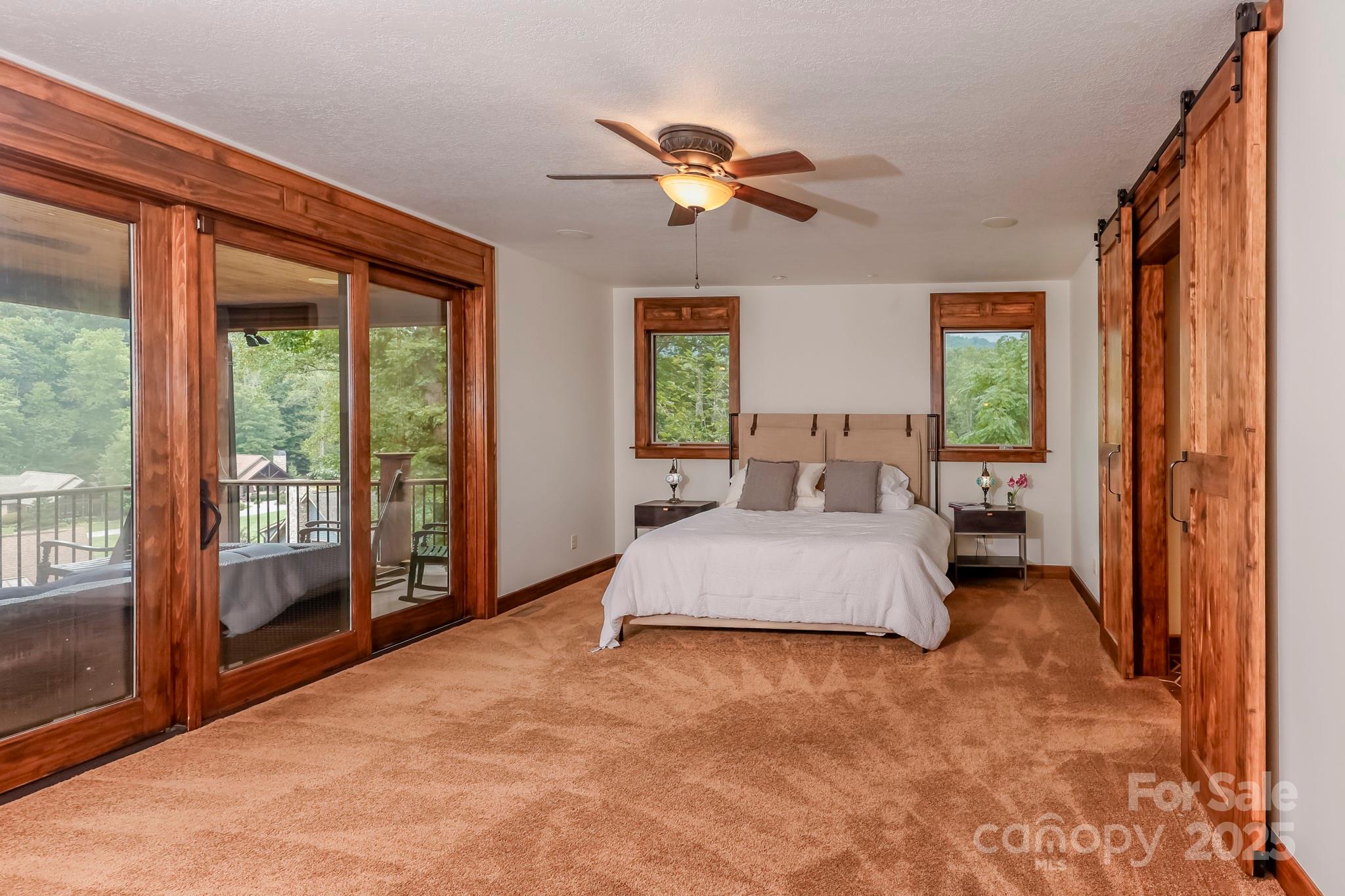 200 Chapel Point Road Lake Lure, NC 28746 - Photo 13 of 48 a spacious bedroom with a large bed and a chandelier