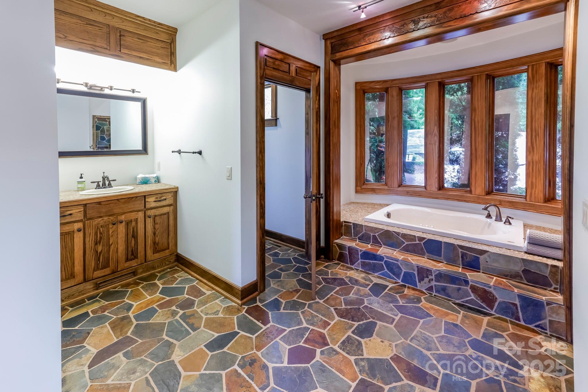 200 Chapel Point Road Lake Lure, NC 28746 - Photo 19 of 48 a bathroom with a double vanity sink mirror and bathtub