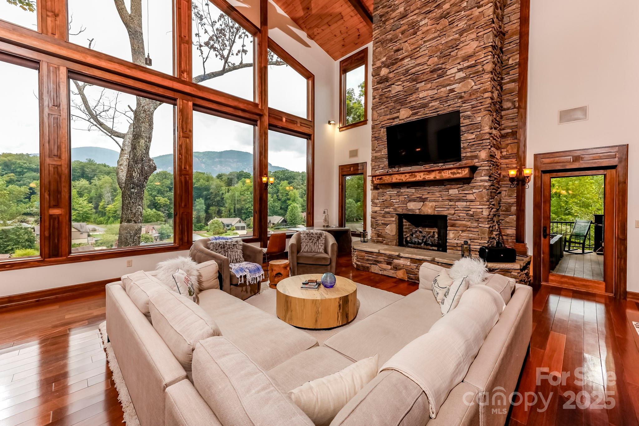200 Chapel Point Road Lake Lure, NC 28746 - Photo 5 of 48 a living room with furniture a flat screen tv and a fireplace
