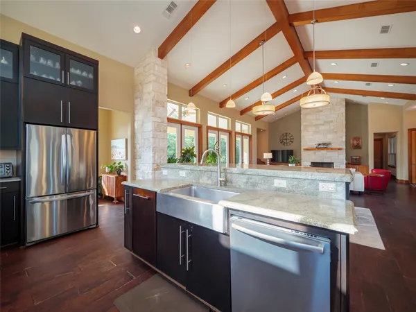 a kitchen with stainless steel appliances granite countertop a refrigerator and a sink