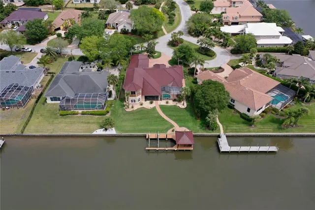 an aerial view of a house with a garden and lake view