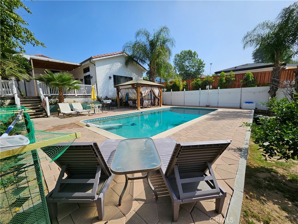 9740 La Canada Way Shadow Hills, CA 91040 - Photo 18 of 28 a view of a patio with table and chairs potted plants with wooden floor and fence