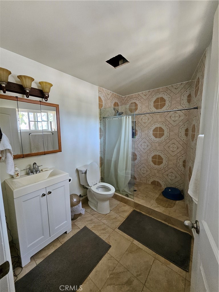 9740 La Canada Way Shadow Hills, CA 91040 - Photo 27 of 28 a bathroom with a granite countertop sink toilet and shower