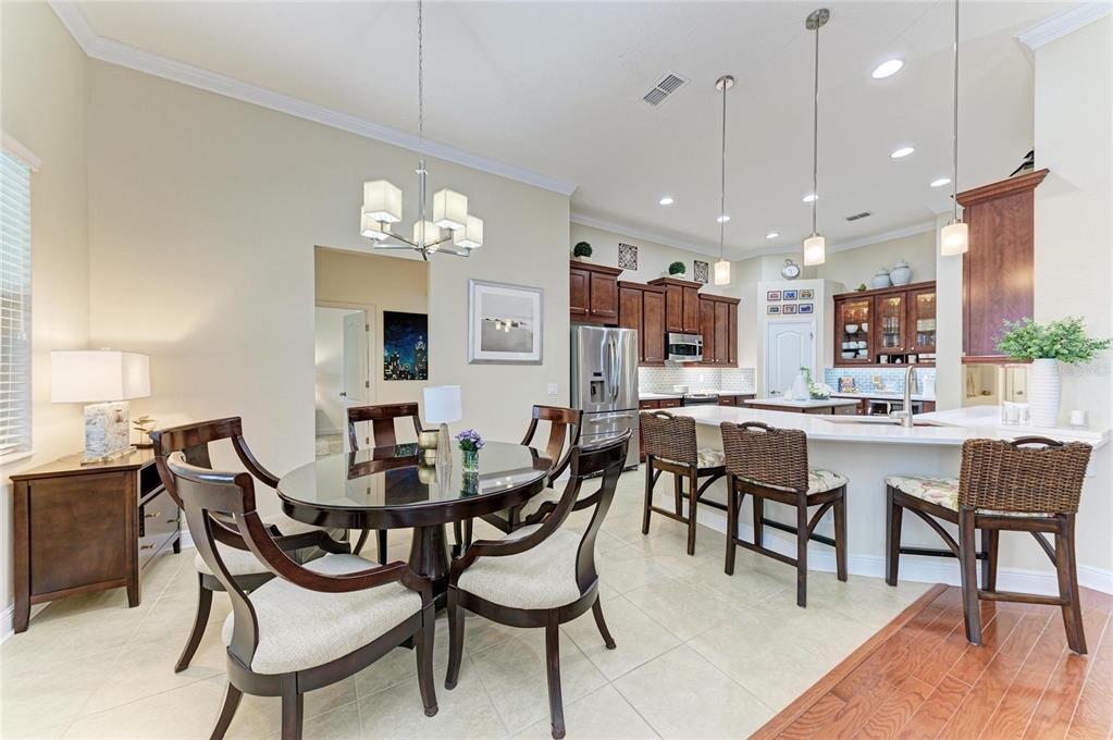 302 Cockle Shell Loop Apollo Beach, FL 33572 - Photo 23 of 75 a dining area with a table chairs and a kitchen view