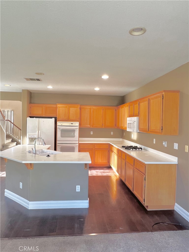 27145 Cherry Grove Court Temecula, CA 92591 - Photo 28 of 61 a large kitchen with kitchen island a large counter top a sink a stove and a window