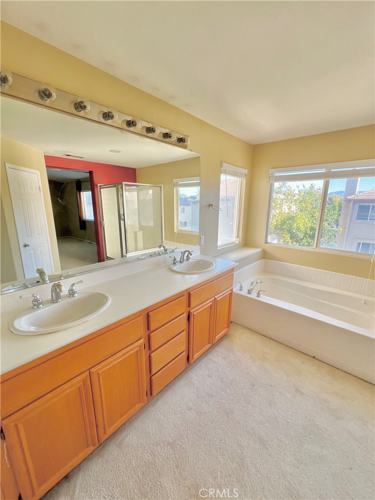 27145 Cherry Grove Court Temecula, CA 92591 - Photo 43 of 61 a spacious bathroom with a granite countertop sink mirror and a bathtub