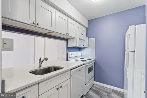 a kitchen with a stove and white cabinets