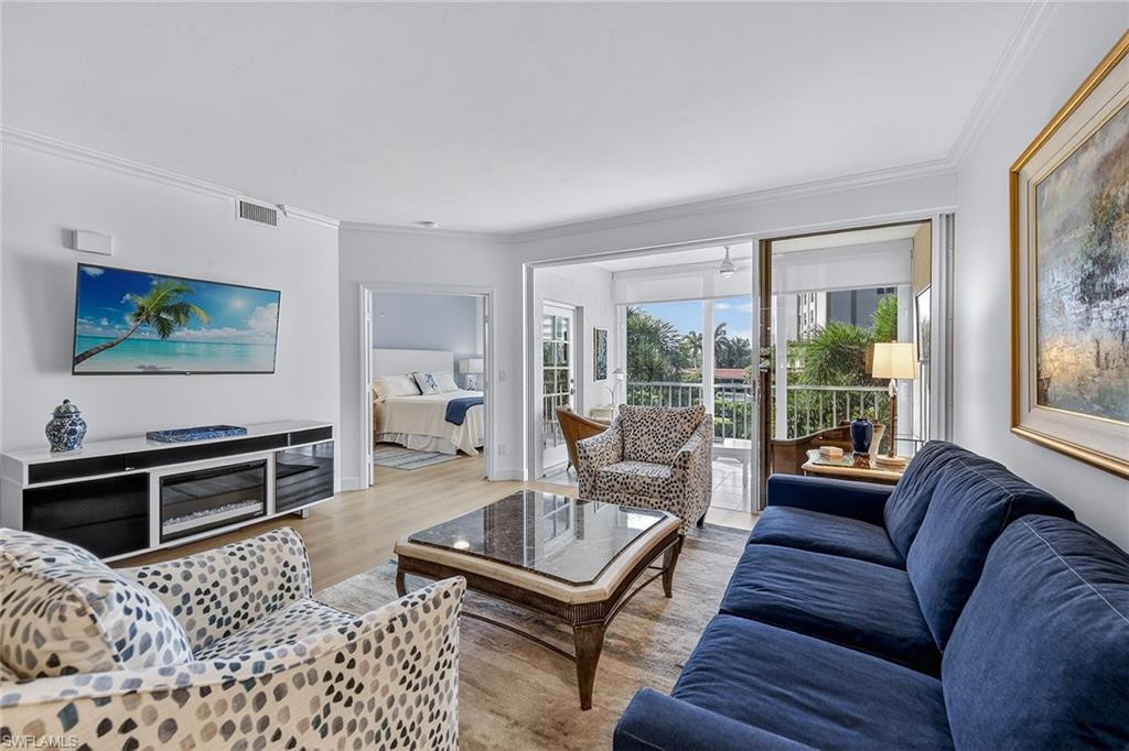 6537 Marissa Loop, Unit 4 Naples, FL 34108 - Photo 11 of 30 a living room with furniture a flat screen tv and a window