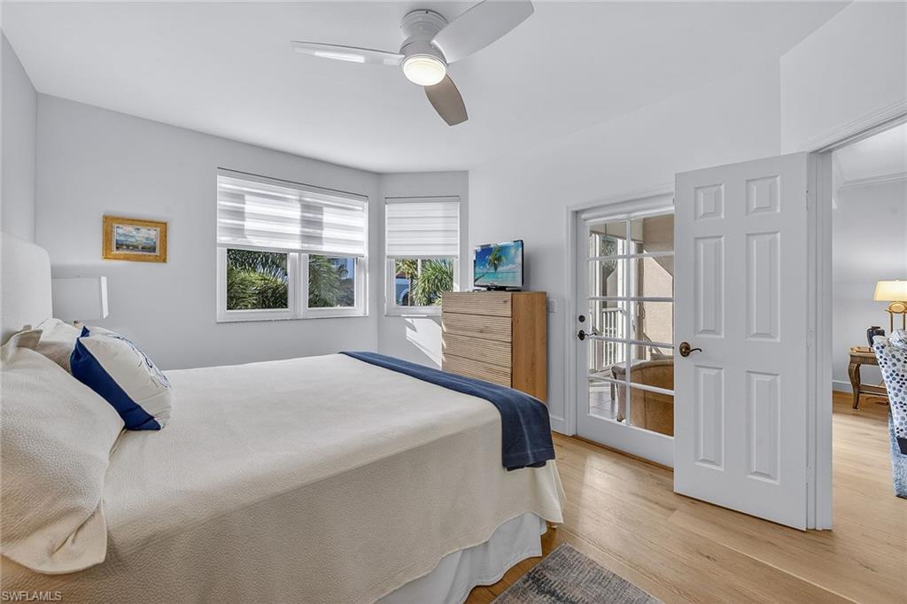 6537 Marissa Loop, Unit 4 Naples, FL 34108 - Photo 14 of 30 a bedroom with a bed flat screen tv and a large window