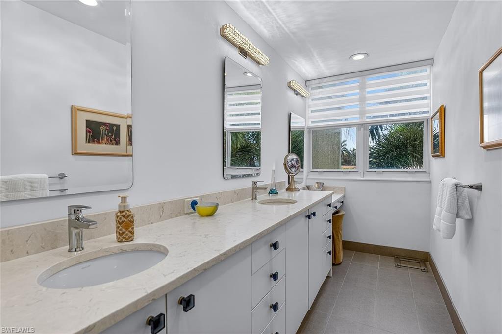 6537 Marissa Loop, Unit 4 Naples, FL 34108 - Photo 15 of 30 a bathroom with a granite countertop sink and a large mirror