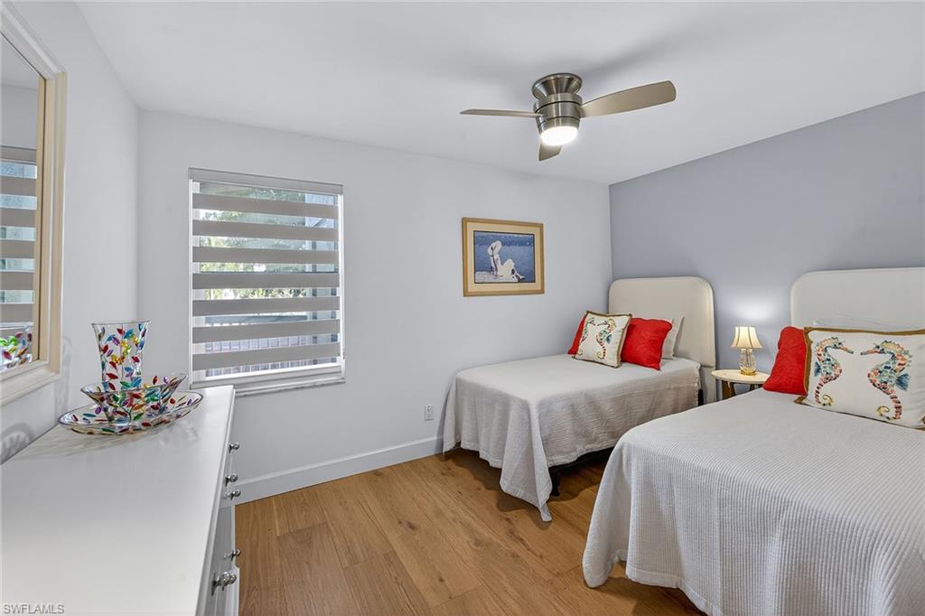 6537 Marissa Loop, Unit 4 Naples, FL 34108 - Photo 18 of 30 a bedroom with two beds and a chandelier