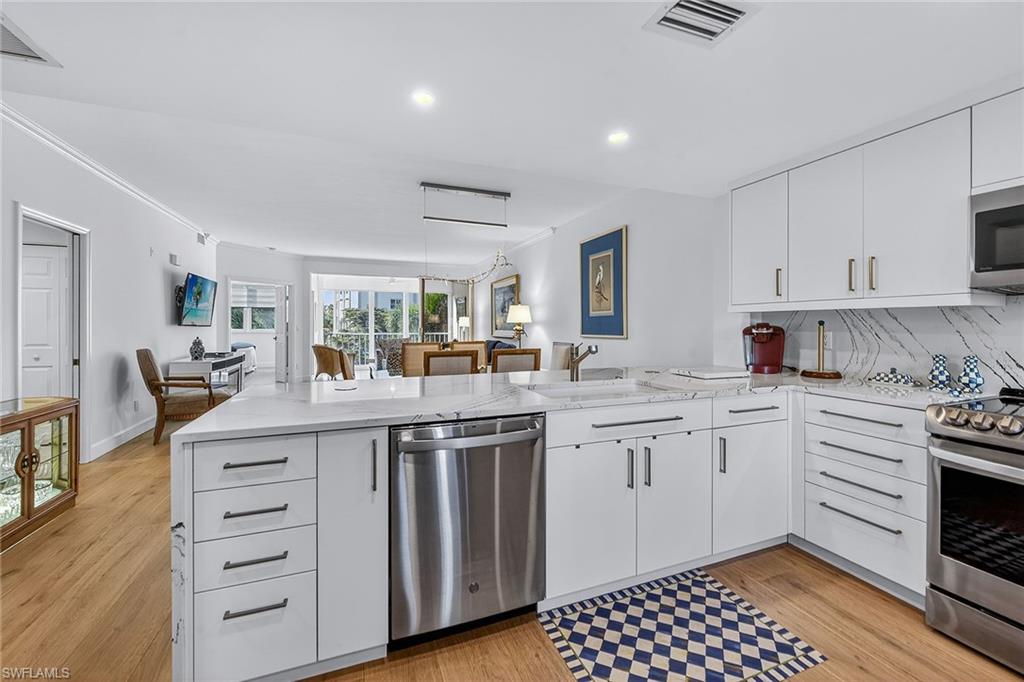 6537 Marissa Loop, Unit 4 Naples, FL 34108 - Photo 4 of 30 a kitchen with granite countertop a sink and cabinets