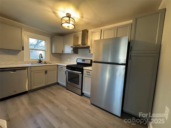 a kitchen with a refrigerator sink and cabinets