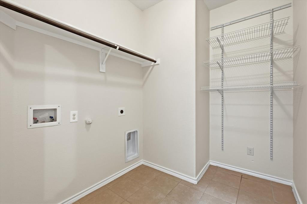 720 Rio Bravo Drive Fort Worth, TX 76052 - Photo 26 of 38 Dedicated utility space featuring a hanging rod, multiple wire shelving units, and tile flooring