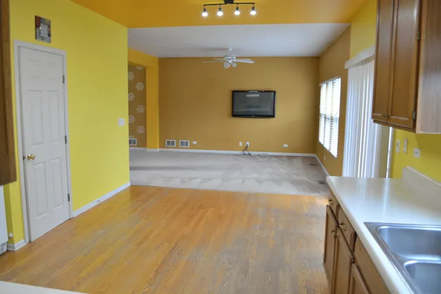 a view of a big room with wooden floor and windows