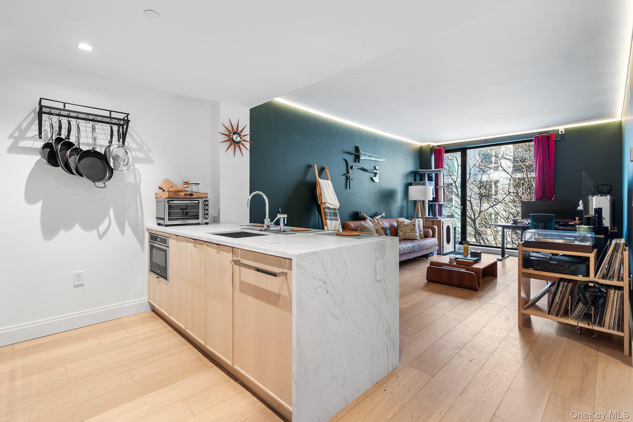 Kitchen featuring light hardwood / wood-style flooring, sink, floor to ceiling windows, and light brown cabinets