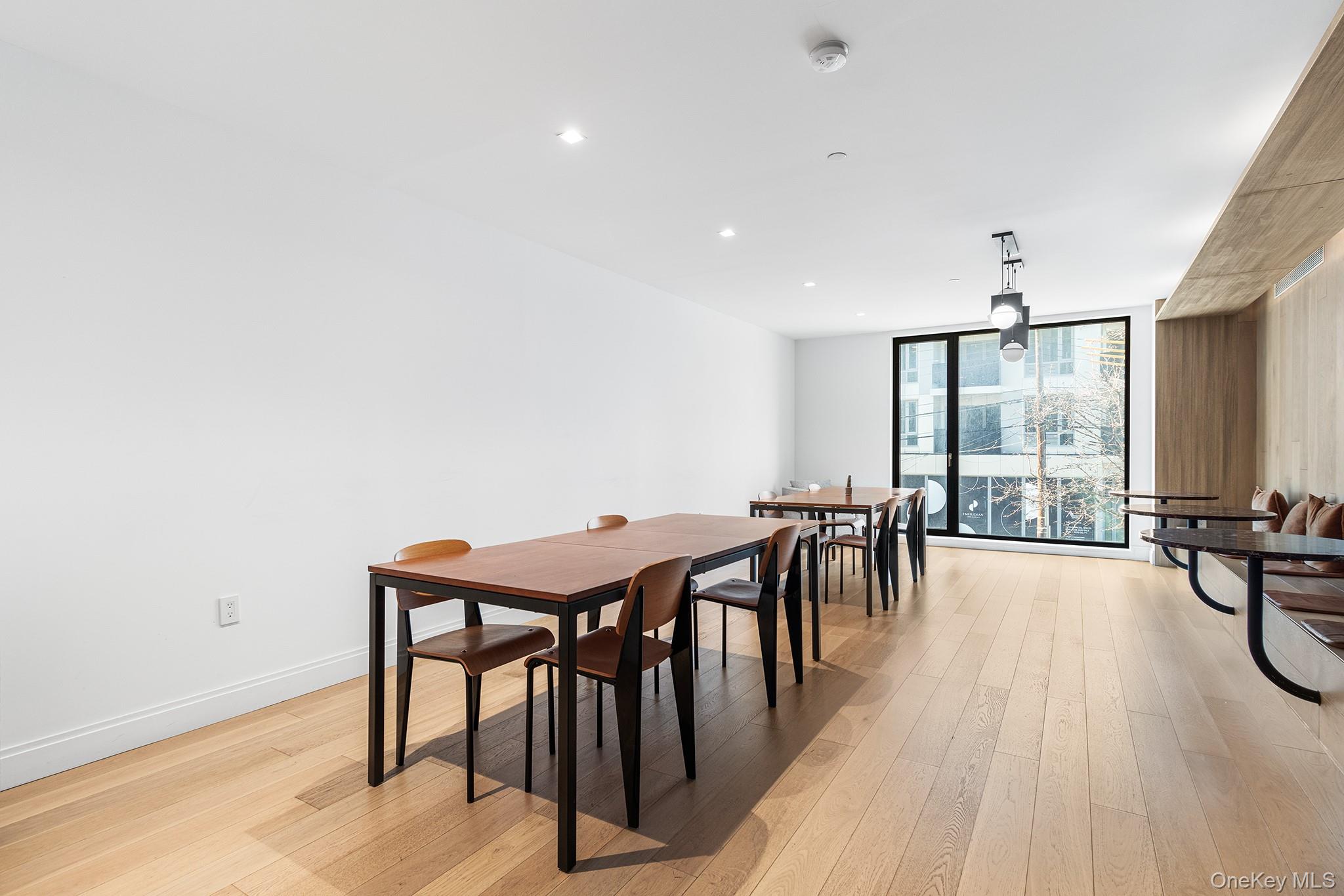 37-14 34th Street, Unit N3E Queens, NY 11101 - Photo 15 of 25 Dining area featuring a wall of windows and light hardwood / wood-style floors