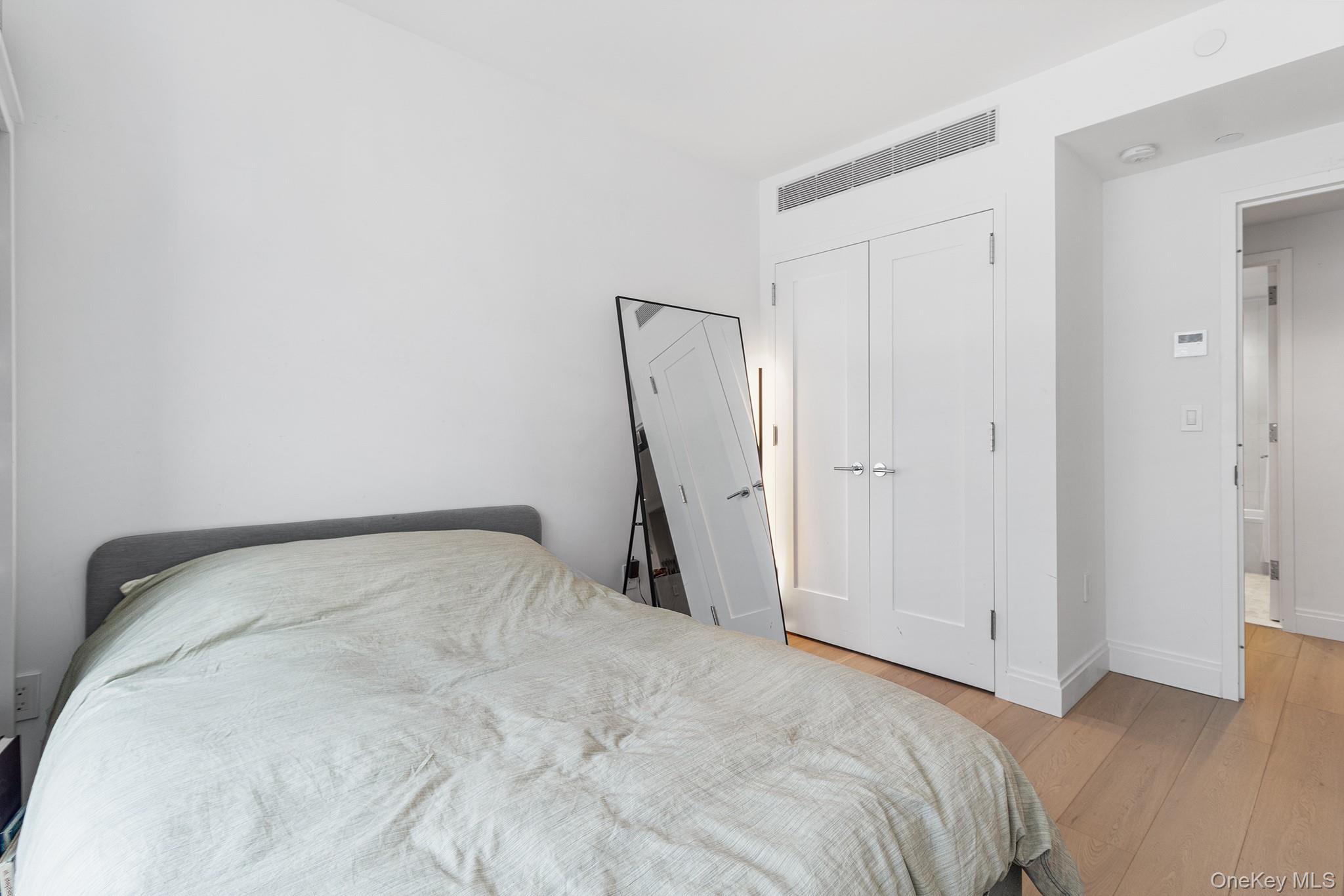 37-14 34th Street, Unit N3E Queens, NY 11101 - Photo 7 of 25 Bedroom with light wood-type flooring and a closet
