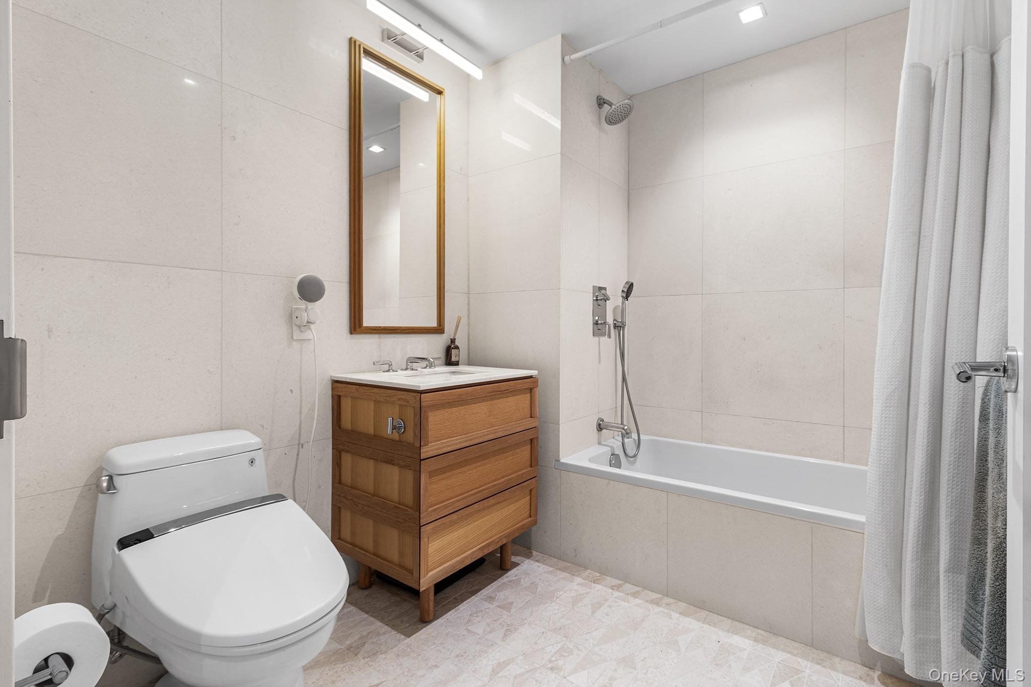 37-14 34th Street, Unit N3E Queens, NY 11101 - Photo 9 of 25 Full bathroom with shower / tub combo with curtain, vanity, tile walls, and toilet