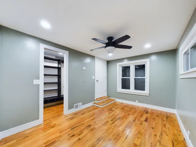 a view of empty room with wooden floor and window