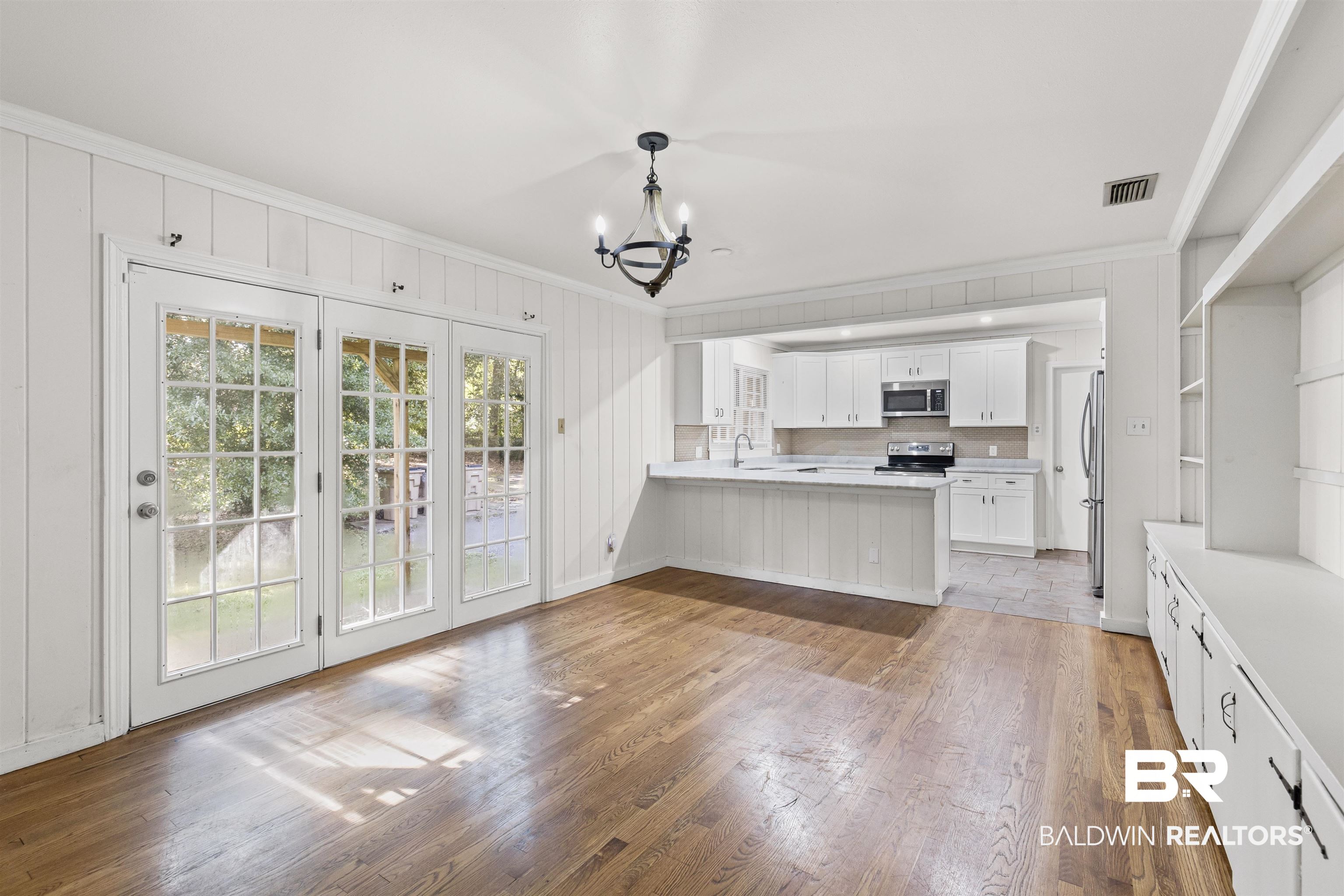 1108 Locarno Street Mobile, AL 36608 - Photo 11 of 24 Kitchen with ornamental molding, a chandelier, light wood-style floors, light countertops, and a peninsula