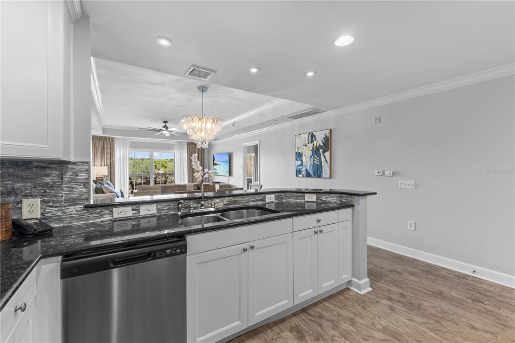 1354 Centre Ct Ridge Drive, Unit 302 Reunion, FL 34747 - Photo 11 of 33 a kitchen with granite countertop a sink and white cabinets