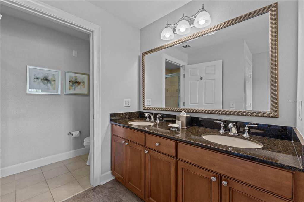 1354 Centre Ct Ridge Drive, Unit 302 Reunion, FL 34747 - Photo 19 of 33 a bathroom with a granite countertop sink a light fixture and a mirror