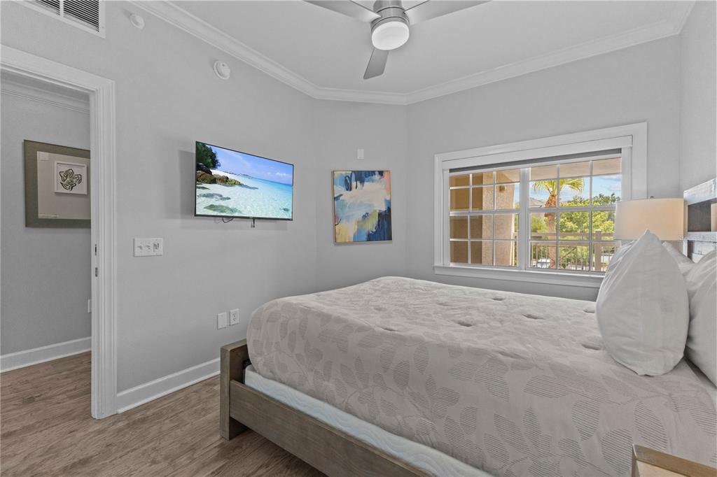 1354 Centre Ct Ridge Drive, Unit 302 Reunion, FL 34747 - Photo 23 of 33 a bedroom with a bed painting on wall and a large window