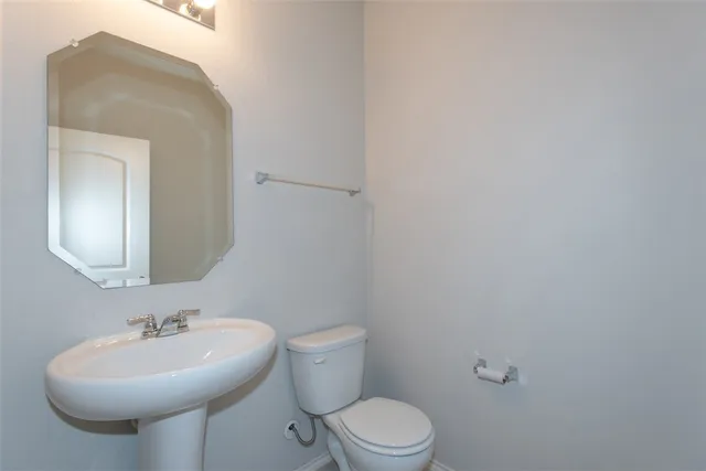 a bathroom with a sink a toilet and mirror