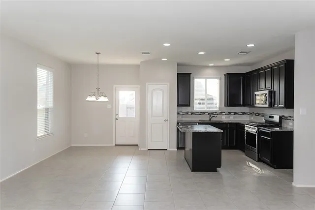 a kitchen with stainless steel appliances granite countertop a stove a sink a refrigerator and a oven