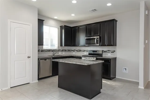 a kitchen with stainless steel appliances granite countertop a stove and a refrigerator