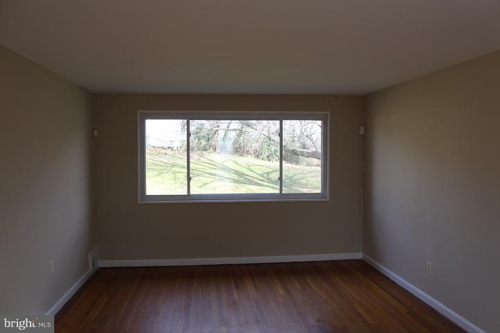 1316 Ray Road Hyattsville, MD 20782 - Photo 14 of 27 an empty room with wooden floor and windows