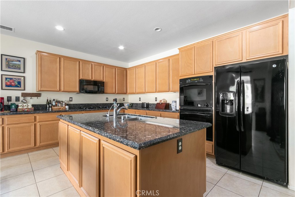 37192 High Ridge Drive Beaumont, CA 92223 - Photo 12 of 71 a kitchen with stainless steel appliances granite countertop a refrigerator a sink a stove a microwave and island