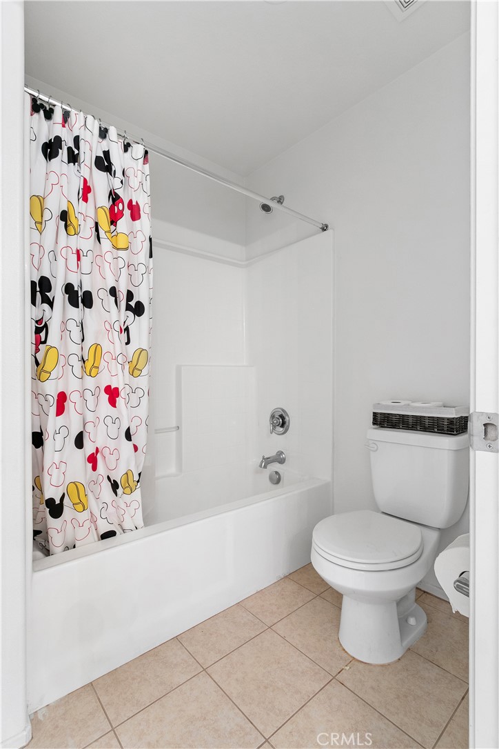 37192 High Ridge Drive Beaumont, CA 92223 - Photo 37 of 71 a white toilet sitting next to a white curtain and a shower curtain